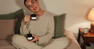 Relaxed mom in cozy loungewear on her bed in the evening holding a jar of CBN gummies, with herbal tea on the nightstand